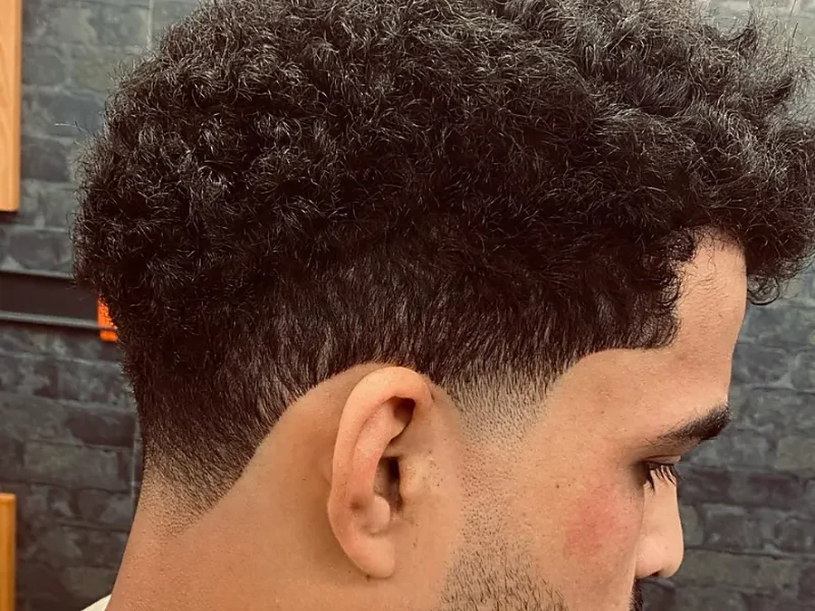 Volle krullende coupe met getrimde baard, zijaanzicht